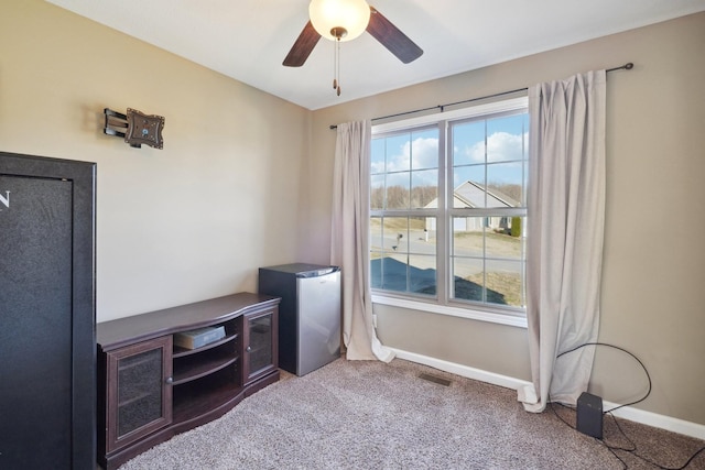 office area with a ceiling fan, carpet flooring, visible vents, and baseboards