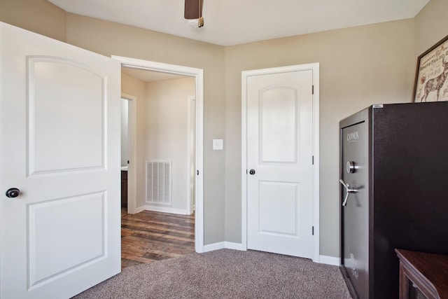 corridor with carpet, visible vents, and baseboards