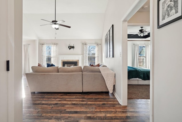 living area featuring dark wood-style floors, plenty of natural light, and a tile fireplace