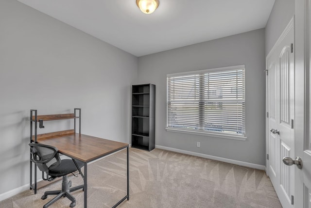 office area featuring light carpet and baseboards