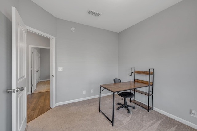 carpeted office with visible vents and baseboards