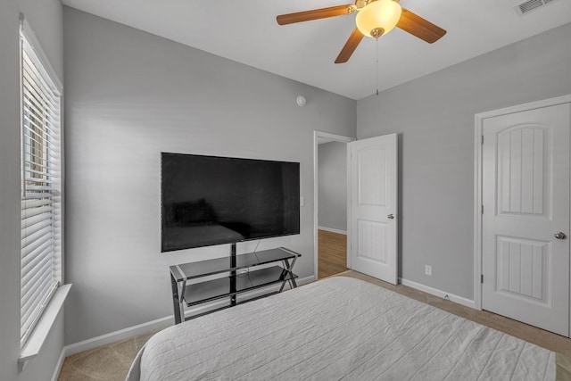 bedroom with carpet floors, visible vents, baseboards, and ceiling fan