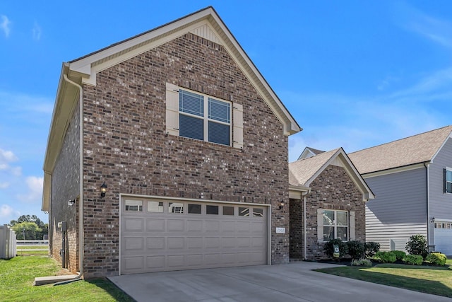 traditional-style house with a garage, a front lawn, concrete driveway, and brick siding