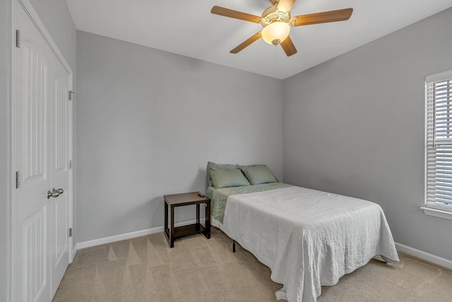 bedroom with light carpet, baseboards, and multiple windows