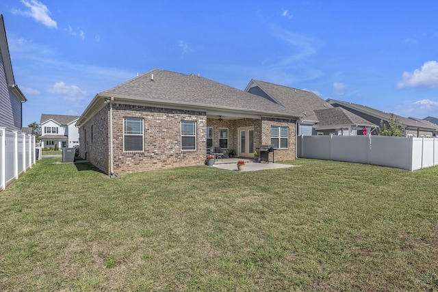 rear view of house featuring brick siding, a lawn, a patio area, and a fenced backyard