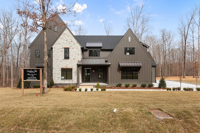 modern farmhouse style home with a standing seam roof, a front yard, covered porch, and board and batten siding