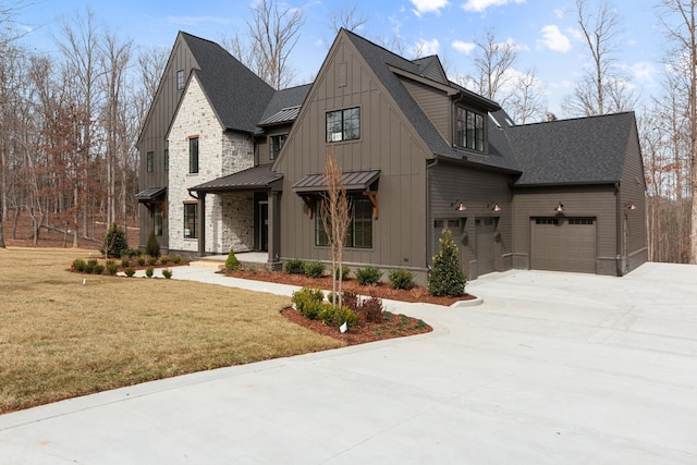 view of front of home with a shingled roof, a front yard, metal roof, driveway, and a standing seam roof