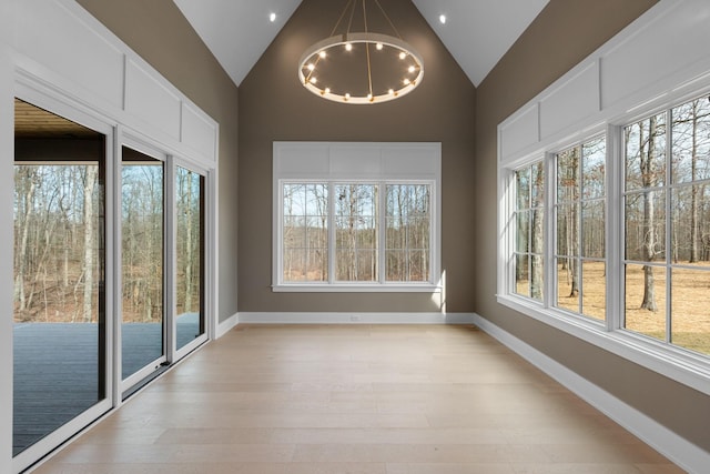 unfurnished sunroom featuring vaulted ceiling and plenty of natural light