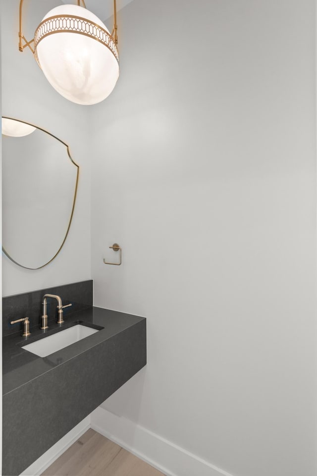 bathroom featuring a sink, baseboards, and wood finished floors