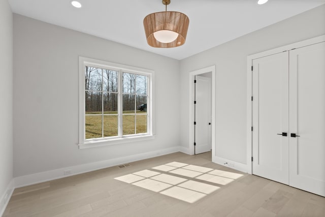 unfurnished bedroom with light wood-type flooring, visible vents, recessed lighting, a closet, and baseboards