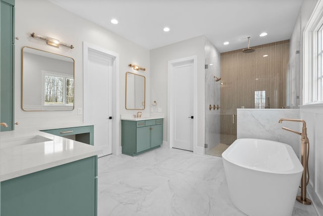 full bathroom with marble finish floor, a freestanding tub, a shower stall, and a sink