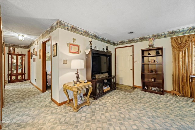 carpeted living area with a textured ceiling and baseboards