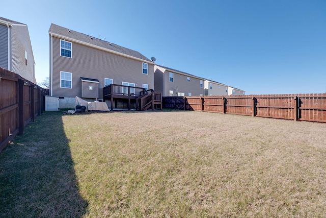 back of property featuring a deck, a yard, and a fenced backyard