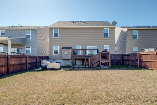 back of house with a fenced backyard, a deck, and a yard