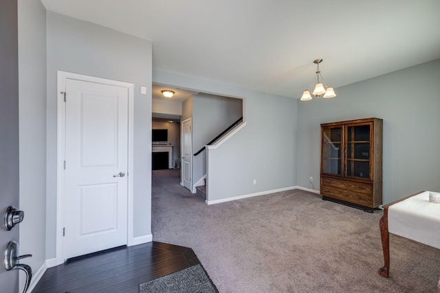 interior space featuring baseboards, stairway, a chandelier, and carpet flooring