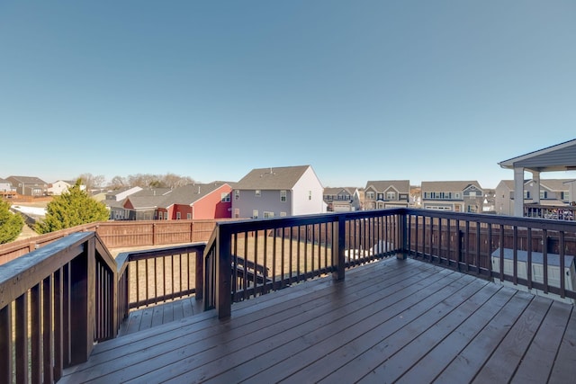 wooden terrace with a residential view and fence