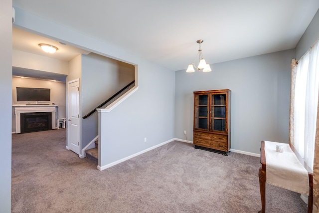 interior space with a chandelier, a fireplace, baseboards, and stairs