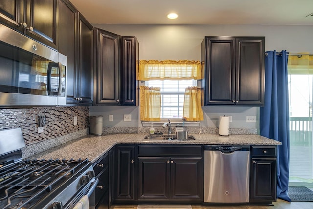 kitchen with stainless steel appliances, tasteful backsplash, a sink, and recessed lighting