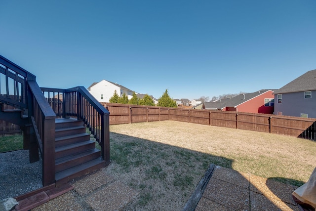 view of yard with stairs, a fenced backyard, and a residential view