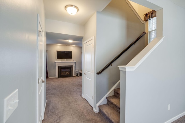 corridor with carpet, stairway, and baseboards