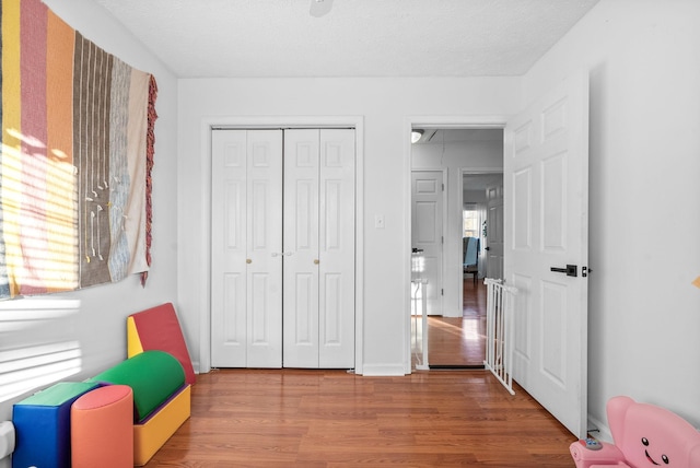 game room with attic access, baseboards, and wood finished floors