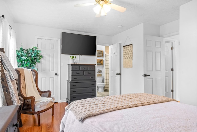 bedroom with light wood finished floors, ceiling fan, and a textured ceiling