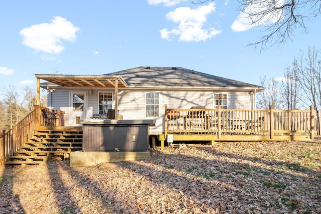 back of property with a deck and stairs