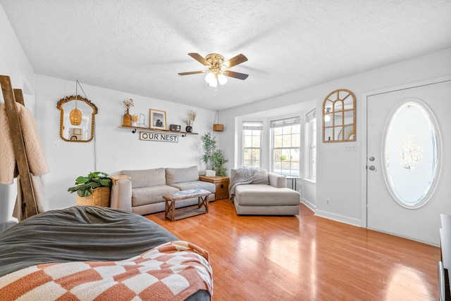 bedroom featuring light wood-style flooring, ceiling fan, and a textured ceiling