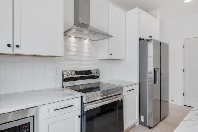 kitchen with white cabinetry, wall chimney exhaust hood, appliances with stainless steel finishes, and backsplash