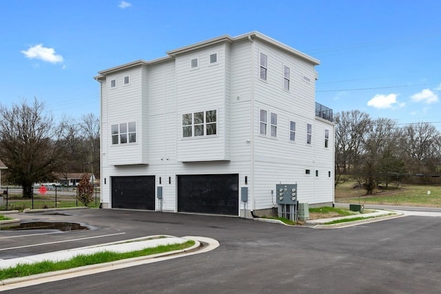 view of side of home with a garage and fence