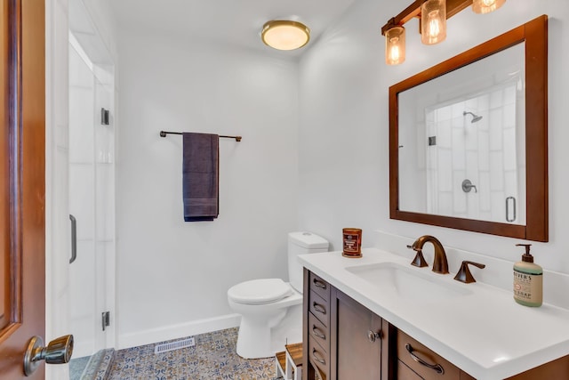 full bathroom featuring baseboards, visible vents, toilet, a shower with shower door, and vanity