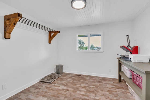 interior space featuring brick floor, wood ceiling, and baseboards