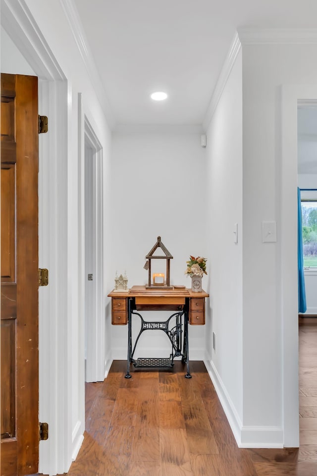 hallway featuring crown molding, baseboards, and wood finished floors