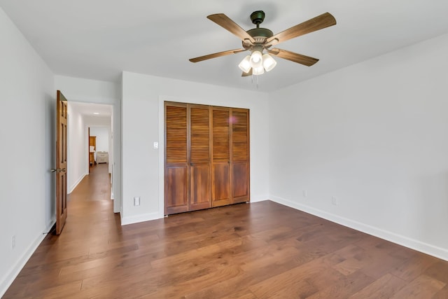 unfurnished bedroom with ceiling fan, a closet, baseboards, and wood finished floors