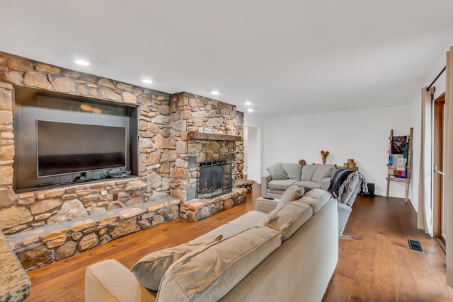 living area with recessed lighting, visible vents, a fireplace, and wood finished floors