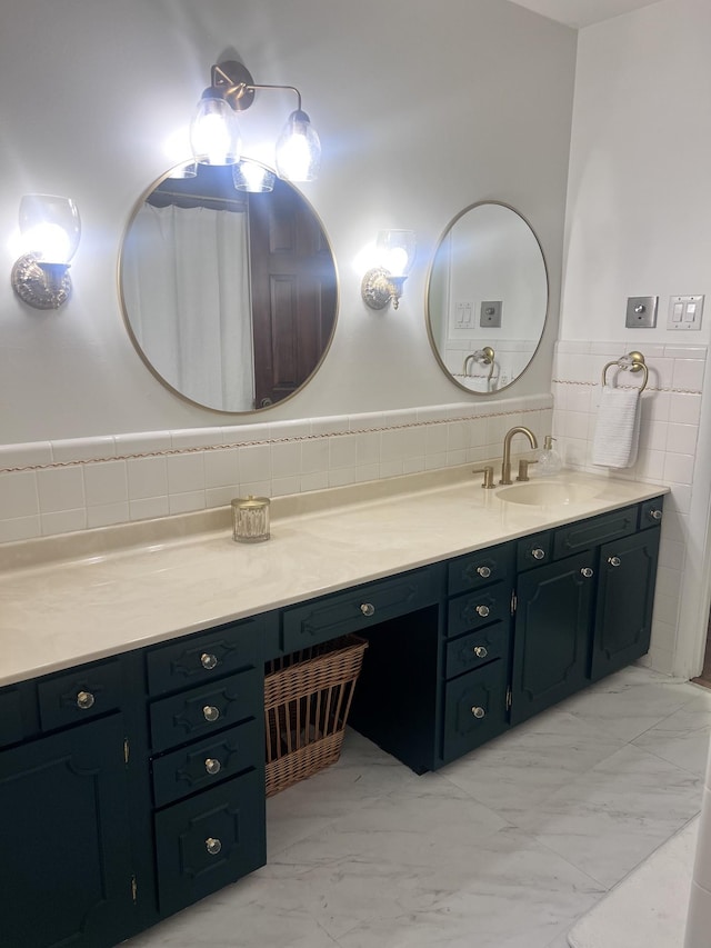 bathroom featuring marble finish floor, tile walls, a wainscoted wall, and vanity