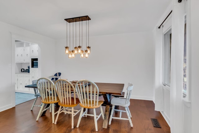 dining area featuring a chandelier, dark wood finished floors, visible vents, and baseboards