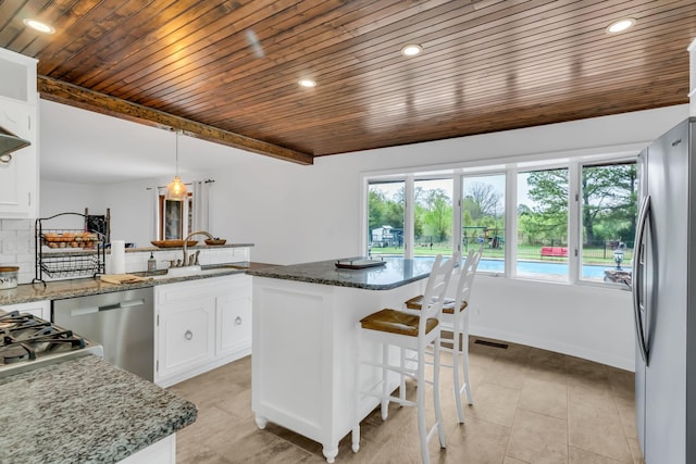 kitchen featuring light tile patterned floors, a sink, white cabinetry, appliances with stainless steel finishes, and tasteful backsplash