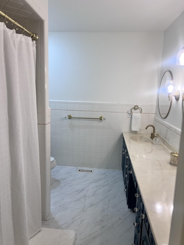 bathroom featuring visible vents, toilet, a wainscoted wall, marble finish floor, and vanity