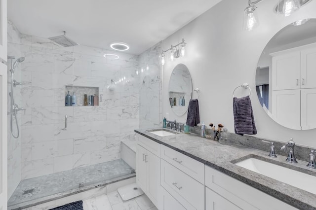 full bath featuring double vanity, marble finish floor, a shower stall, and a sink