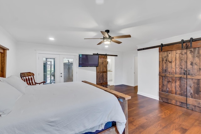 bedroom featuring a barn door, wood finished floors, a ceiling fan, access to outside, and french doors