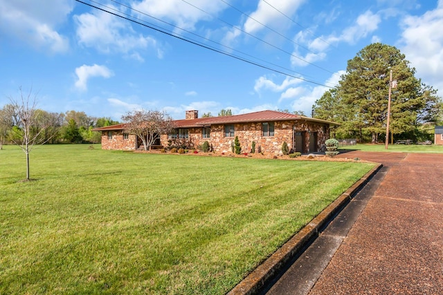 ranch-style house with a chimney and a front lawn