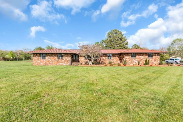 ranch-style house with stone siding, metal roof, and a front lawn