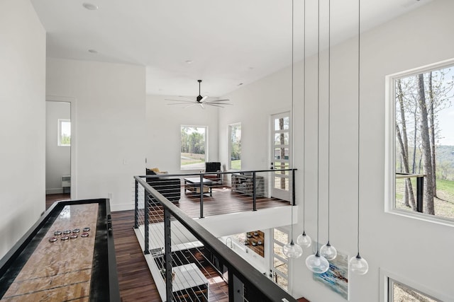 corridor featuring dark wood-type flooring, an upstairs landing, and baseboards