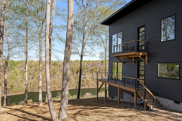 view of yard featuring a balcony, a forest view, and stairs