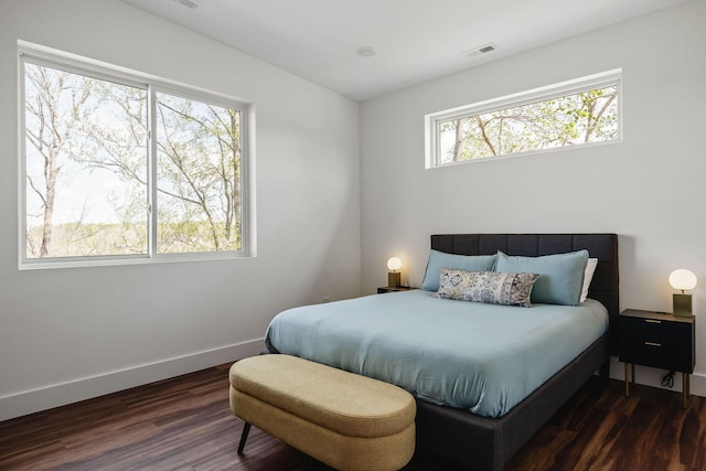 bedroom featuring visible vents, baseboards, and wood finished floors