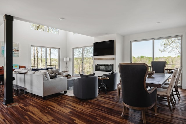 living area featuring dark wood-style flooring and a glass covered fireplace