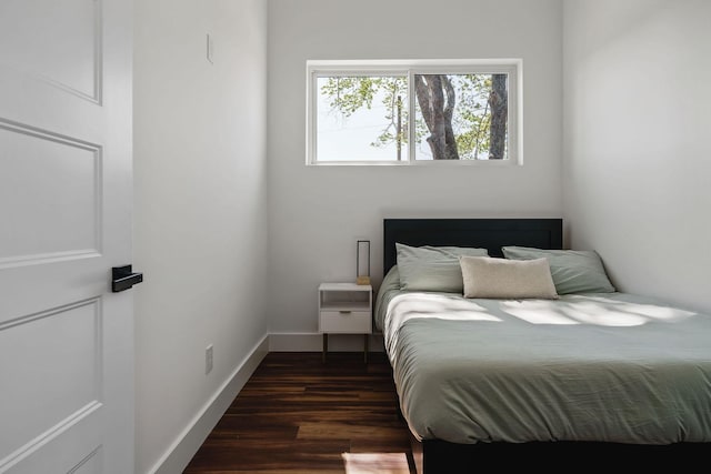 bedroom featuring dark wood-style floors and baseboards