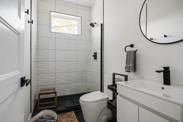 bathroom with toilet, a stall shower, and vanity