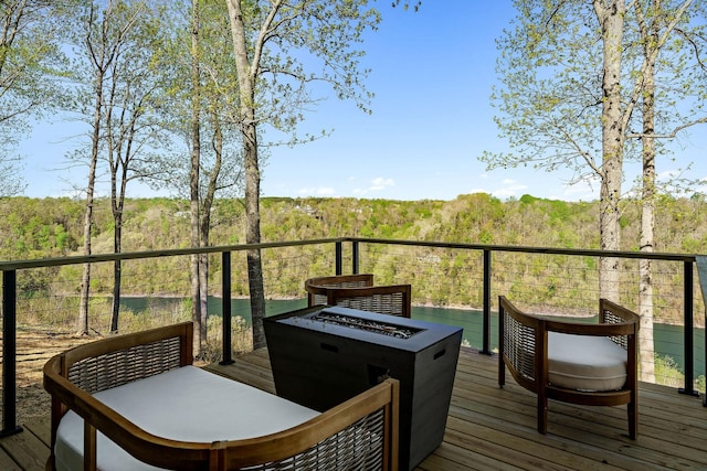 deck featuring a forest view and a fire pit